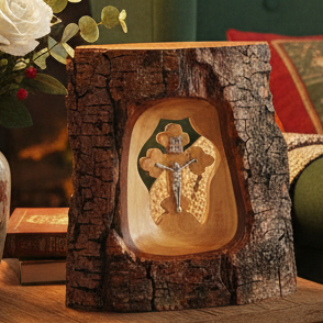 Wooden plaque with a cutout design of a cross and Jesus Christ on a tree trunk background