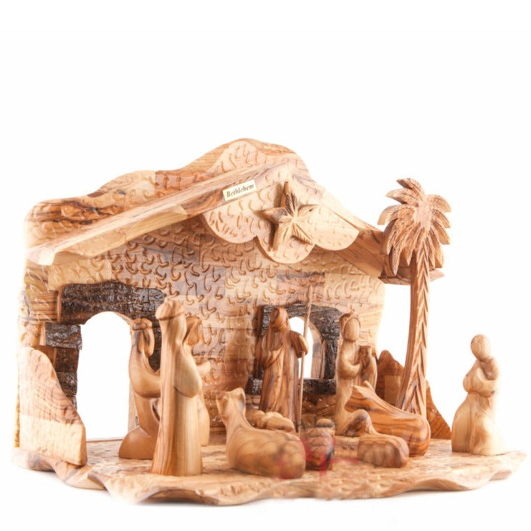 A hand-carved olive wood nativity scene featuring figures of the three Magi, the virgin Mary, and Joseph, with a depiction of the stable in Bethlehem.