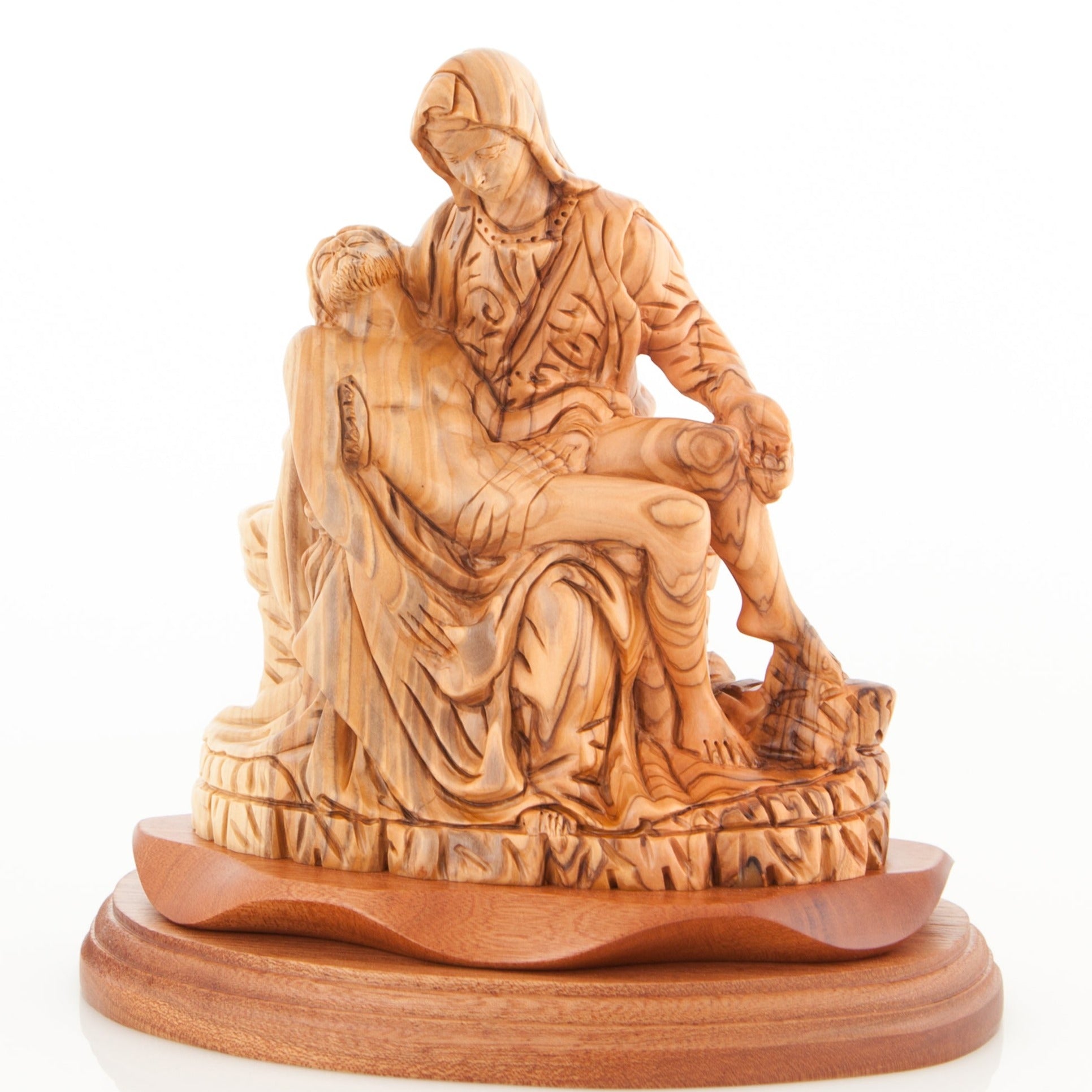 An olive wood carving statue of the Pieta, featuring Virgin Mary and Christ Crucified, placed on a wooden base.