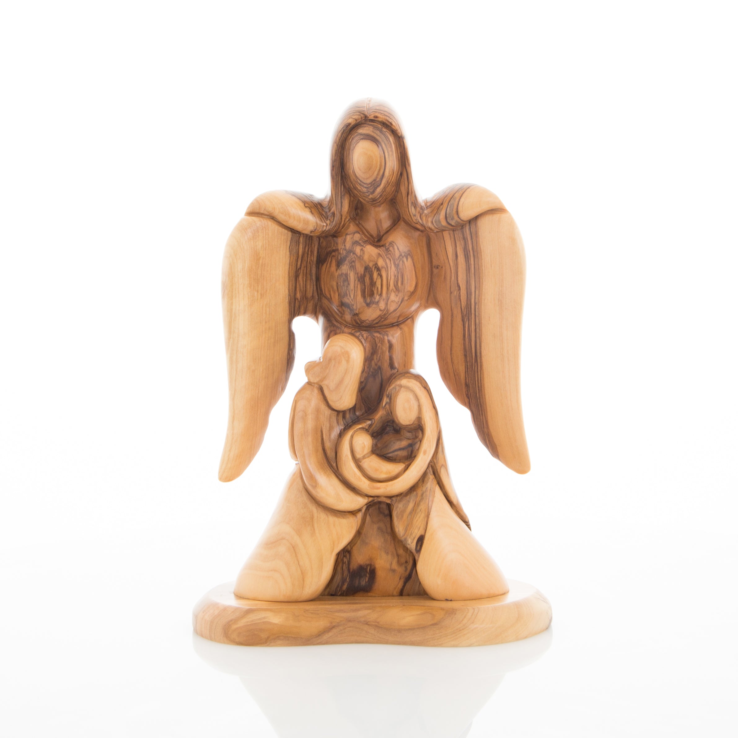 A wooden carving of a guardian angel with outstretched wings, depicting the Holy Family with Mary, Joseph, and Baby Jesus.