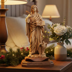 A hand-carved olive wood statue of St. John the Evangelist with a quill and an eagle, placed on a wooden base.