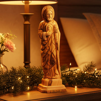 A hand-carved olive wood statue of St. Jude Thaddaeus, with a flame around his head, holding a Christ image.