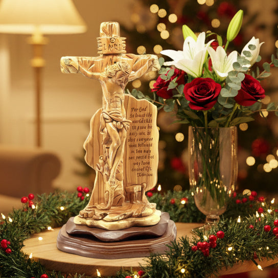 A wooden sculpture of Jesus Christ crucified on a cross, with the verse John 3:16 engraved on its base, compared in size to a standard ruler.
