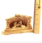 A polished olive wood nativity scene with a shelf and base, featuring figures of the baby Jesus and the mother Mary, placed next to a ruler for scale.