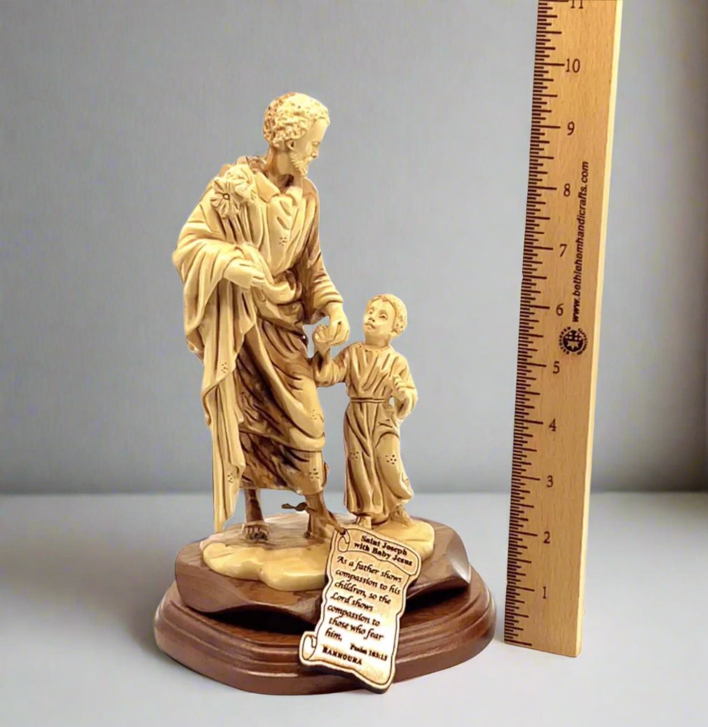 A wooden carving of Saint Joseph with Child Jesus Christ, alongside a ruler for scale.